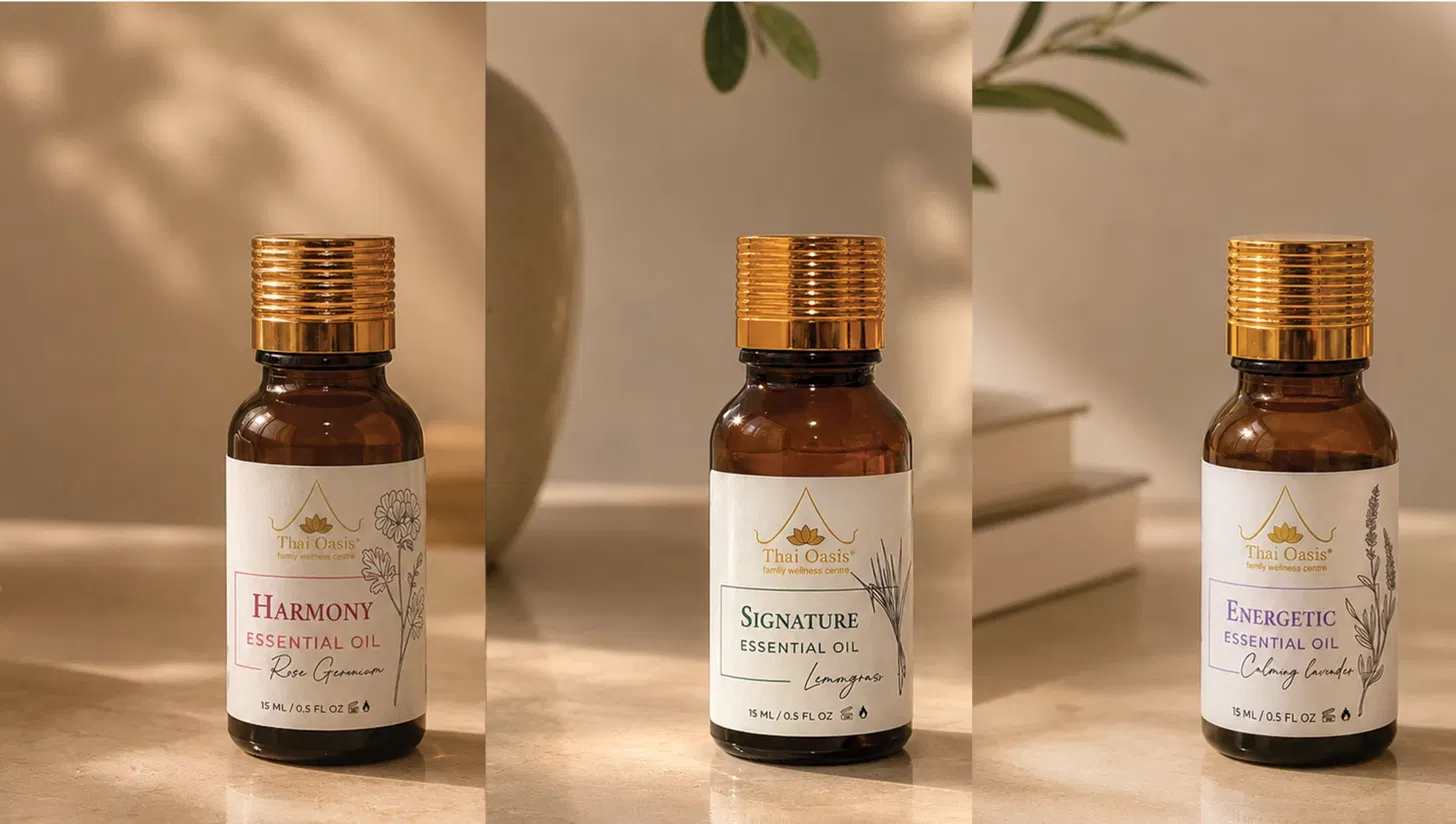 Three Thai Oasis essential oil bottles in amber glass with gold caps — Harmony with rose geranium, Signature with lemongrass, and Energetic with calming lavender, each 15ml